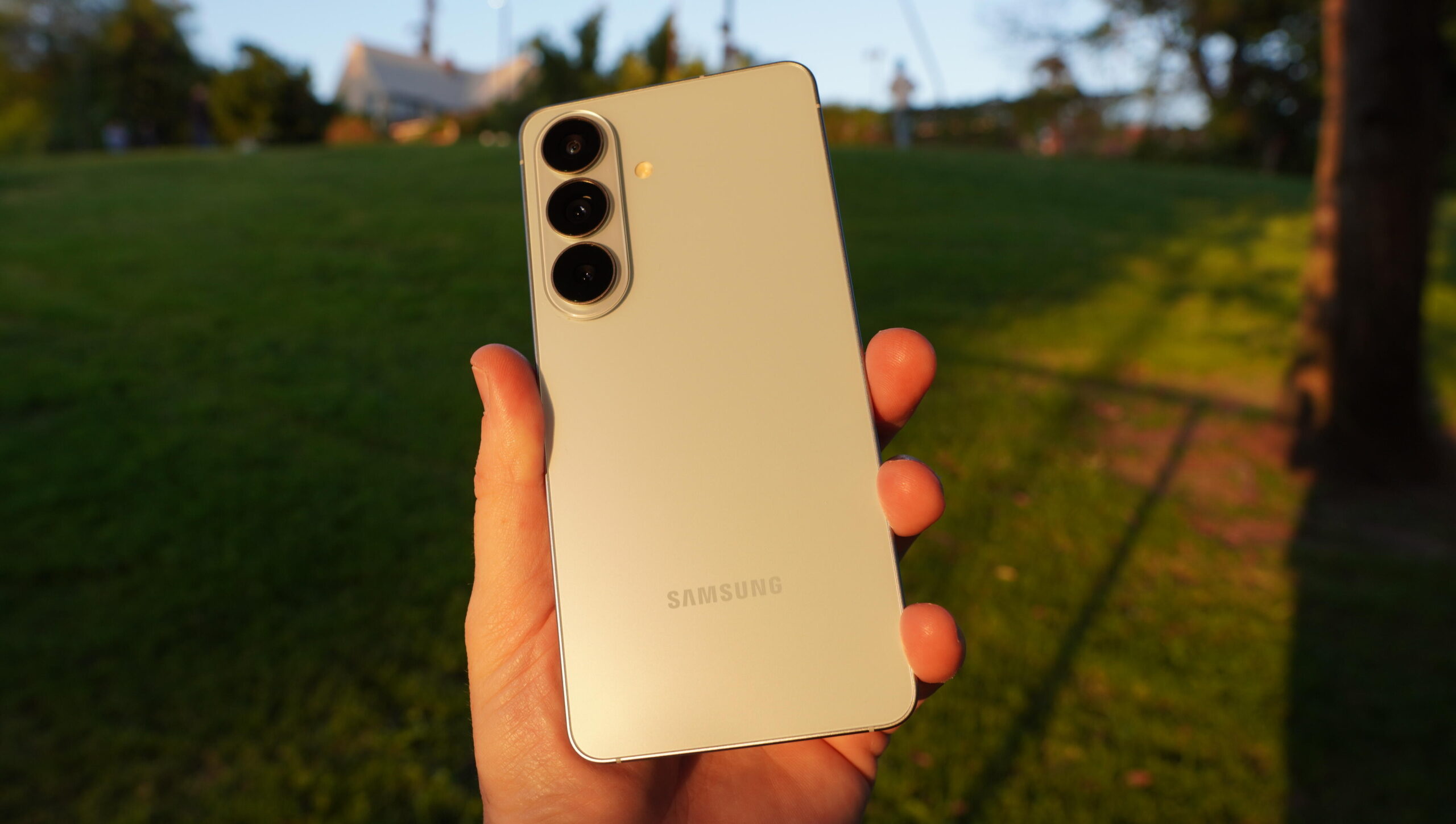 Ljusblå Samsung Galaxy S26 hålls upp i solnedgången